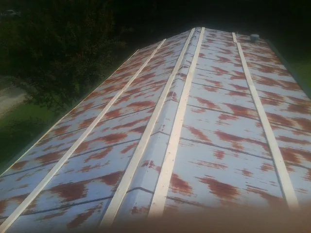Rusted metal roof panels with new wood purlins before replacement — Storm Damage Roof Repair in Moreland by Roofing Brothers