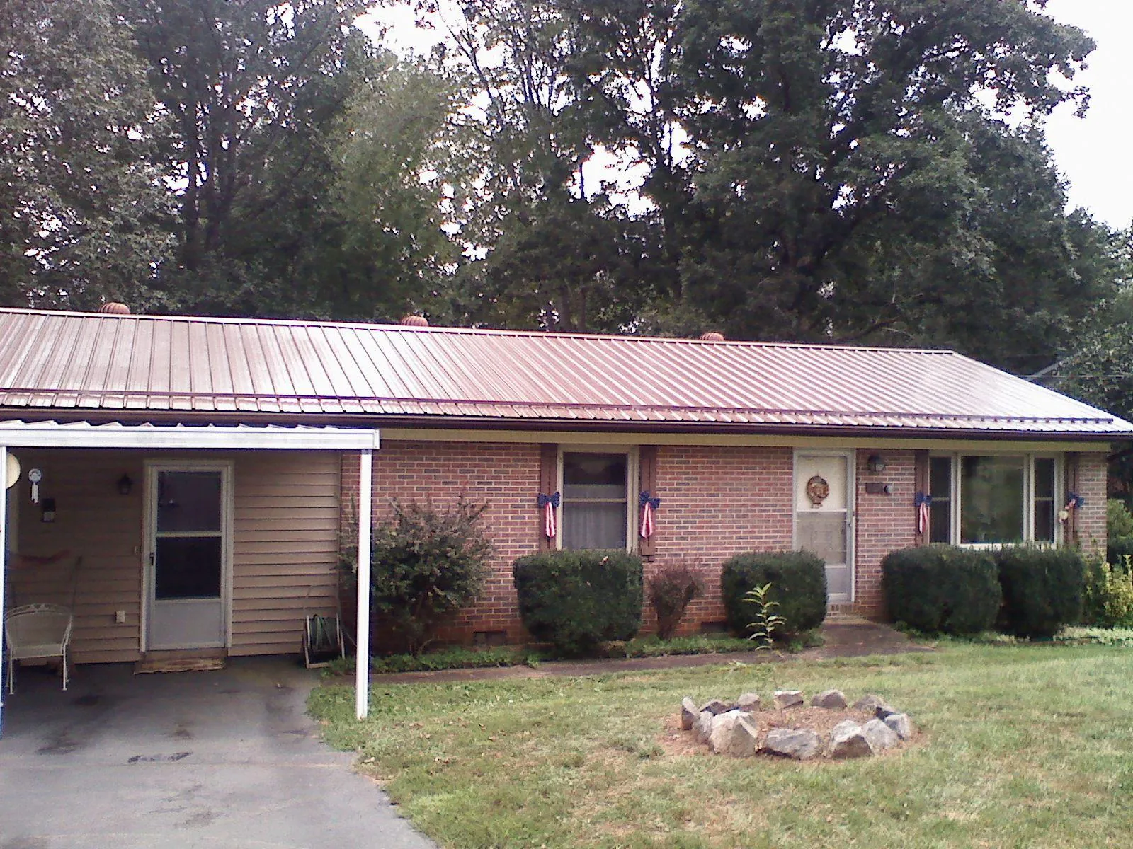 Bronze metal roof and carport on a brick ranch home — Roof Repair work by our crew in Moreland